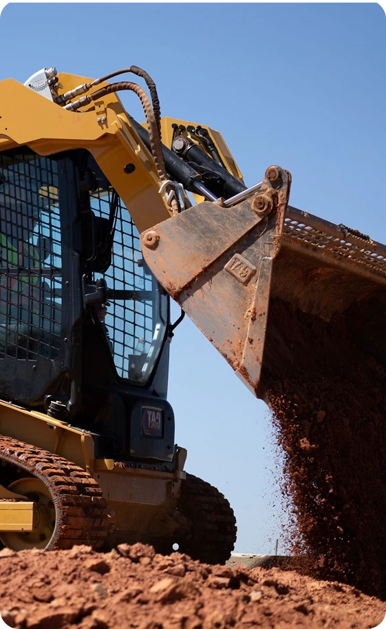 Concrete flatwork service that highlights a CAT compact loader leveling the surface