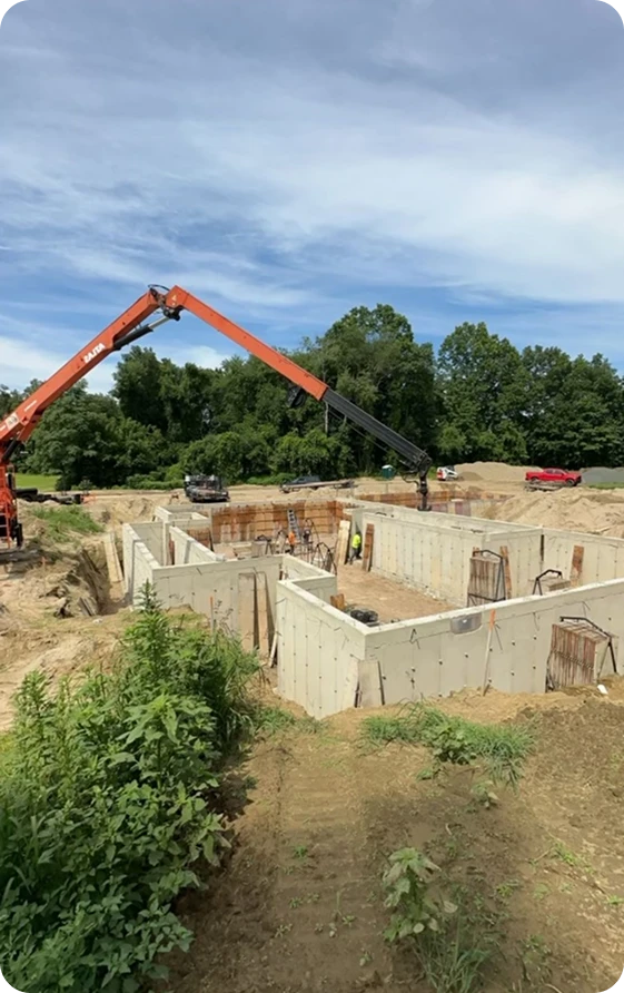 Concrete foundation services, highlighting a building's concrete foundation along with a concrete pumping vehicle at the site